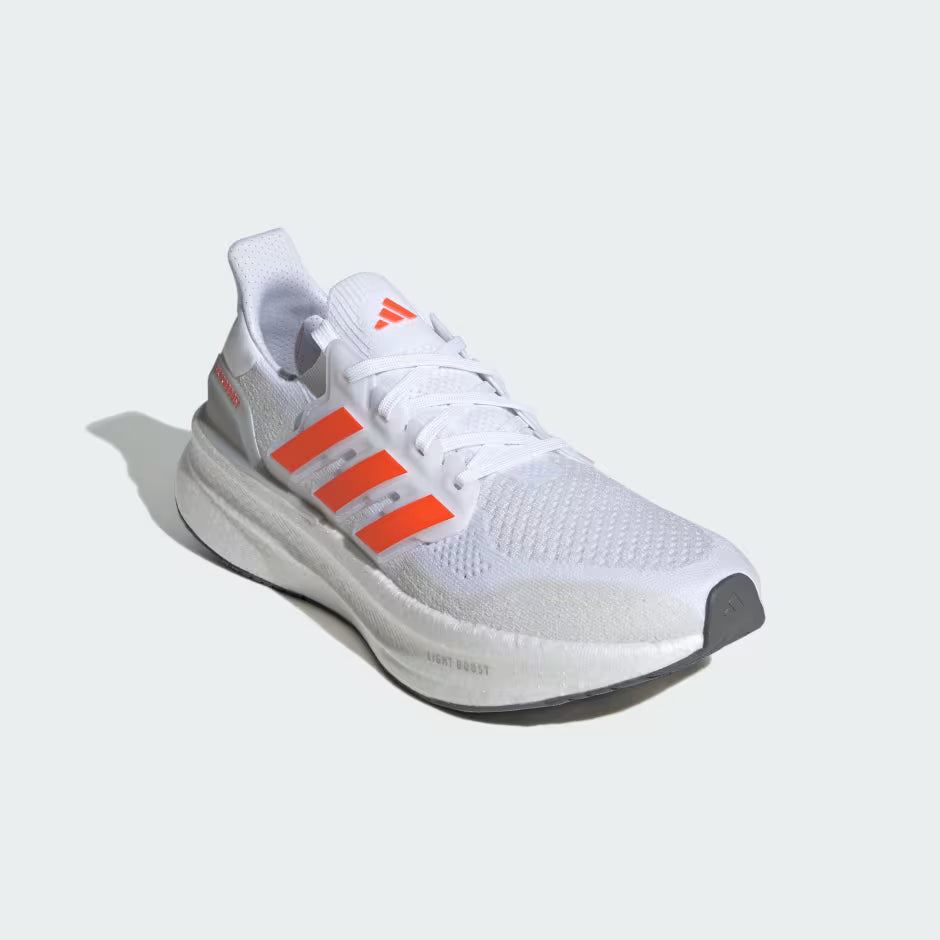White running shoe with orange accents on a light gray background