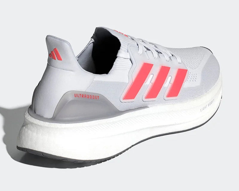 White running shoe with red stripes on a light gray background